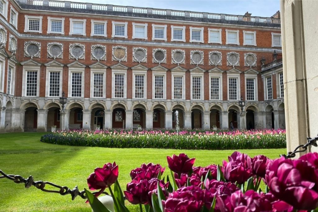 Hampton Court Palace - spending more days in London leaves time for day trips. Palace courtyard featuring tulip blooms in the central garden.