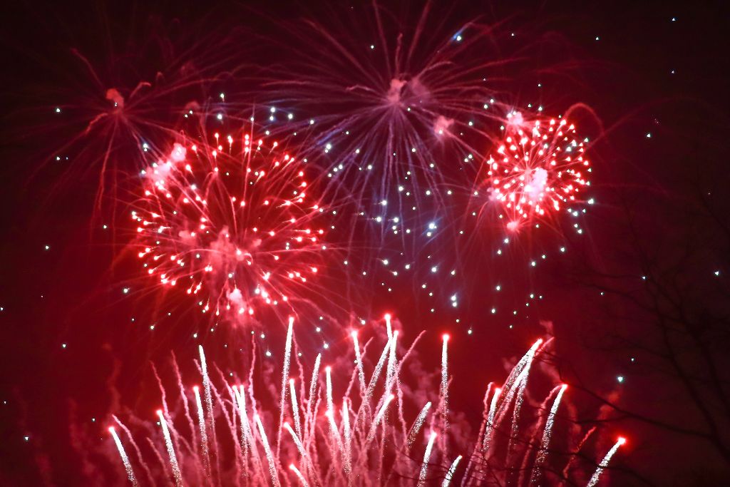 Fireworks explode against a dark night sky as part of a Guy Fawkes Night celebration.
