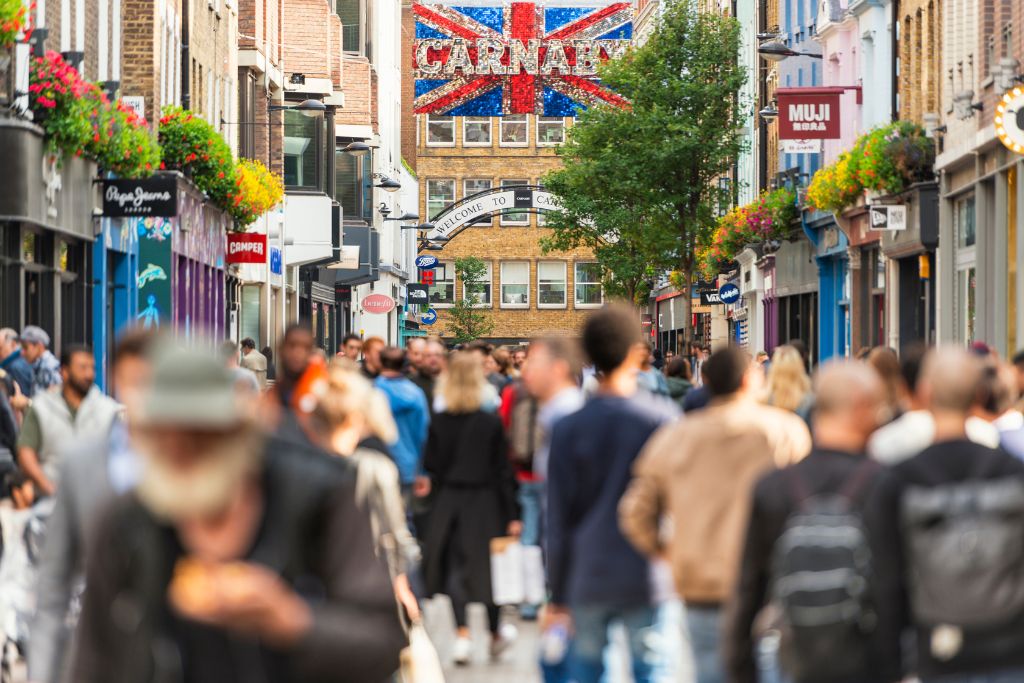 People walk down Carnaby Row in London.