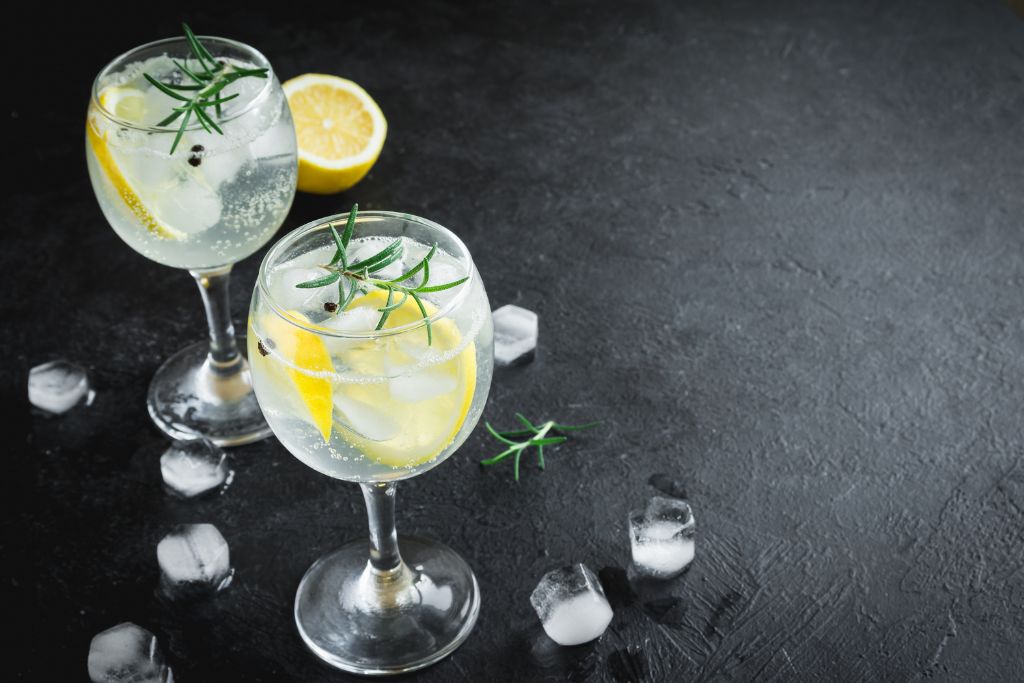 Two gin and tonic cocktails on a black surface. Gin is a very popular liquour in England and can be a fun souvenir.