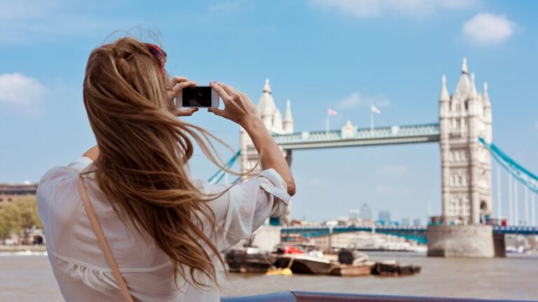 First time tourist in London photographing Tower Bridge