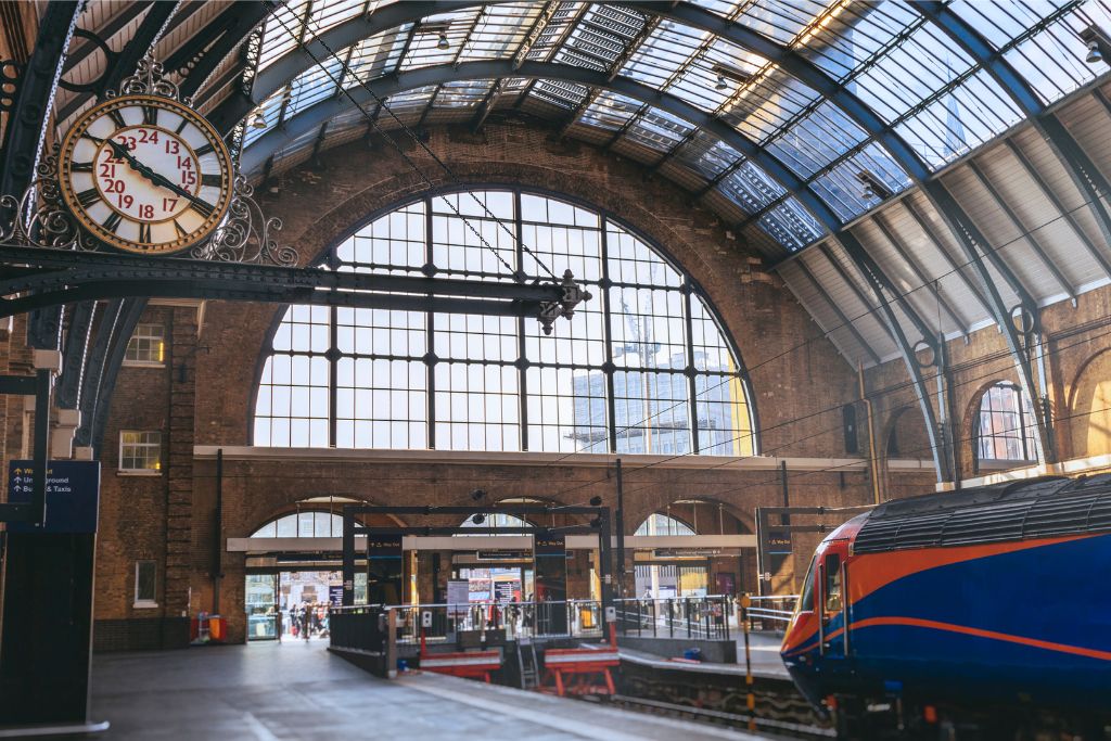 Kings Cross station platform with train and clock under arched roof