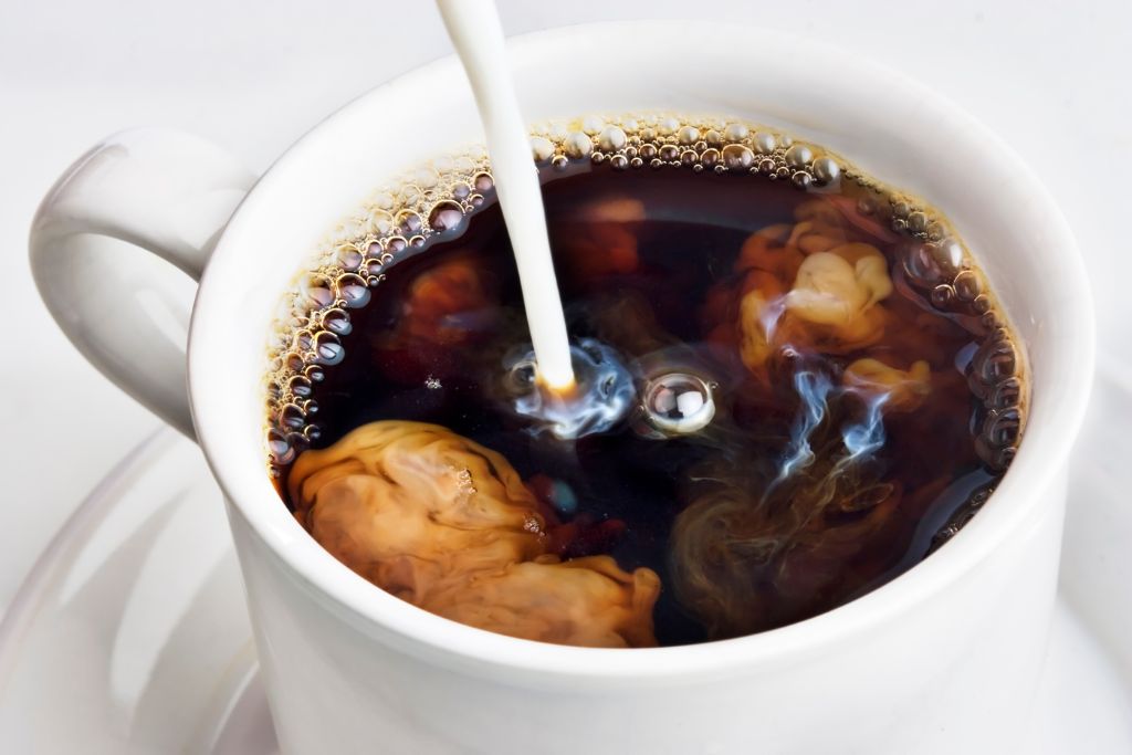 Coffee creamer poured into a cup of coffee. Creamer is one of the American things you can't find in the UK.